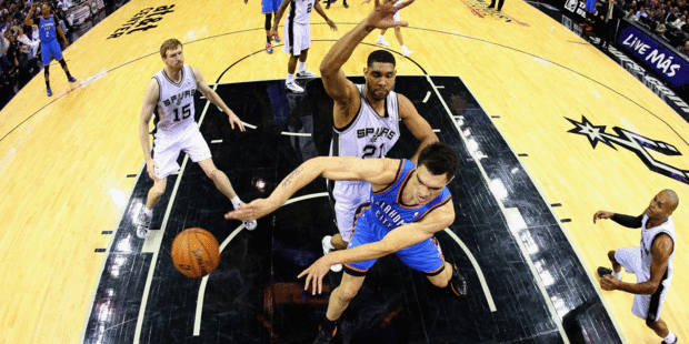 Steven Adams withstands the attentions of Tim Duncan to fire a pass to Derek Fisher during the Thunder's loss. Photo / Getty