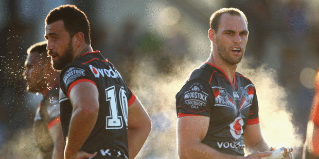 Ben Matulino of the Warriors loooks on as Simon Mannering of the Warriors sprays his hands during the round one NRL match. Photo / Getty Images.