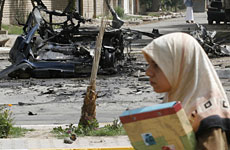 A student walks past the wreckage of a vehicle used in a car bomb attack in Baghdad. Photo / Reuters A student walks past the wreckage of a vehicle used in a car bomb attack in Baghdad. Photo / Reuters