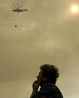 A woman watches a forest fire at Chiliomodi, a few miles off Corinth city, west of Athens. Photo / Reuters A woman watches a forest fire at Chiliomodi, a few miles off Corinth city, west of Athens. Photo / Reuters