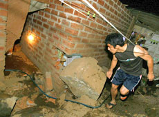 A man surveys the damage to his house after a jolt measuring 7.9 devastated the region A man surveys the damage to his house after a jolt measuring 7.9 devastated the region
