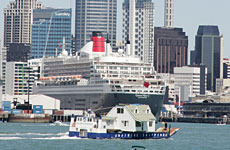 A barge carrying a house passes the Queen Mary harboured at Auckland. Photo / Janna Dixon A barge carrying a house passes the Queen Mary harboured at Auckland. Photo / Janna Dixon
