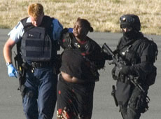 The woman who stabbed two pilots on an Eagle Air flight is escorted by armed police. Photo / Reuters The woman who stabbed two pilots on an Eagle Air flight is escorted by armed police. Photo / Reuters