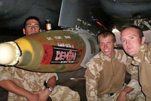 New Zealand soldiers in Afghanistan pose with a bomb inscribed, 'Dear Taleban, enjoy this', and adorned with a Demon energy drink sticker. Photo / Supplied