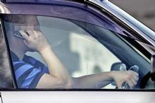 It is now illegal to hold your cellphone while driving - even while stopped at a red light or in gridlock. Photo / Herald on Sunday It is now illegal to hold your cellphone while driving - even while stopped at a red light or in gridlock. Photo / Herald on Sunday
