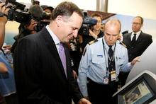 Prime Minister John Key tries his hand at the new SmartGate kiosk at Auckland Airport. Photo / NZPA Prime Minister John Key tries his hand at the new SmartGate kiosk at Auckland Airport. Photo / NZPA
