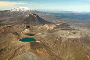 The starkly beautiful Central Plateau with the Blue Lake of Mt Tongariro, Mt Ngauruhoe and snow-capped Mt Ruapehu. Photo / Greg Bowker