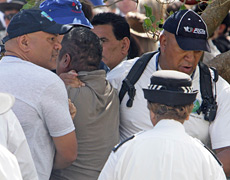 Police lead away one of two protesters who lunged at John Key. Photo / NZPA Police lead away one of two protesters who lunged at John Key. Photo / NZPA