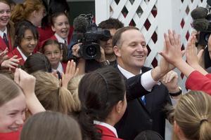 Prime Minister John Key high-fiving with students on a visit to Chilton St James School in Lower Hutt. Photo / Mark Mitchell