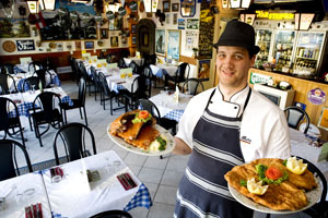 German chef Dennis Poschmann holds the pork spare ribs and wiener schnitzel dishes available at German restaurant Der Metz. Photo / Babiche Martens