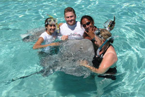 Our guide Taaroa (second from right), tourists and a very friendly ray. Photo / Jill Worrall