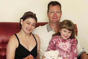 Angela and Alan Symes are seen at home with daughter Caitlin, 6. Photo / Christine Cornege