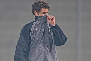 Tony Lochhead tries to block out the smoke which disrupted the All Whites’ first training session in South Africa today. Photo / Brett Phibbs