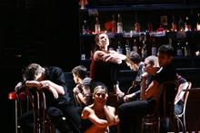 Pieter Symonds as Carmen seated on table at Bar Pastia with her friends around her. Photo / Maarten Holl. Pieter Symonds as Carmen seated on table at Bar Pastia with her friends around her. Photo / Maarten Holl.