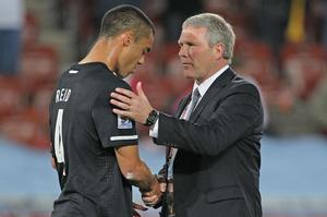 All Whites coach Ricki Herbert consoles Winston Reid after this morning’s draw against Paraguay. Photo / Brett Phibbs