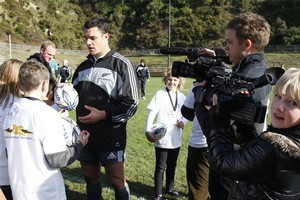 Sarah Mitchell, (11)of Waikanae, videos All Blacks first five-eighths Dan Carter as he signs autographs after their training session in Wellington earlier this month. Photo / Mark Mitchell