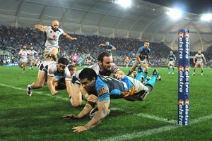 Kevin Gordon of the Titans breaches the Warriors' tryline. Photo / Getty Images
