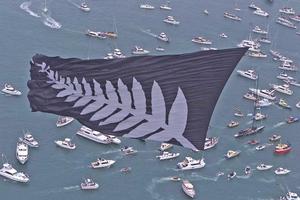 A giant silver fern flag flies over spectator boats following a victorious Team New Zealand back to base in 2000. Photo / Brett Phibbs