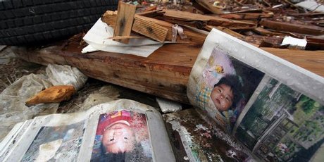 Photo albums lie open in the ruins of Rikuzentakata. many of those in the pictures are still missing. Photo / Bradley Ambrose