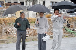 Japan's Emperor Akihiro and Empress Michiko are shown around by the mayor of Soma City (right). Photo / AFP