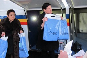 Ballantynes workers Wendy Tauranga (l) and Girl's Day Out host Denise Bird (r) hand out shopping bags at the end of a shopping trip to Timaru for quake hit Christchurch people deprived of their upmarket store. Photo / Amanda Cropp