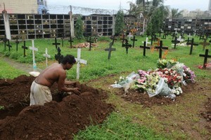 An Indian worker digs a non-permanent grave at a cemetery on the grounds of St Andrew's Church in Bandra, one of the oldest Roman Catholic places of worship in Mumbai. Photo / AFP
