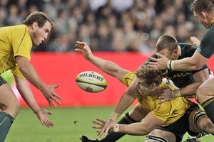 Australia's David Pocock passes the ball to teammate Ben Alexander during his team's narrow win this morning. Photo / AP