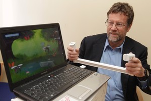 Im-Able's Geoff Todd with a device that helps stroke patients regain muscle control. Photo / Mark Mitchell