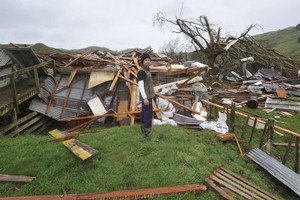 Craig Ferris and whats left of the woolshed on the Pehiri Rd Farm he works on. Photo / Gisborne Herald