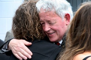 Bernie Monk embraces a supporter after a memorial service for his son Michael. Photo / Herald on Sunday