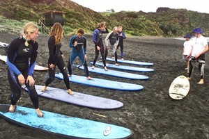 Learners work on their stance under the watchful eyes of their teachers at Raglan Surfing School, Ngarunui Beach. Photo / Derek Flynn