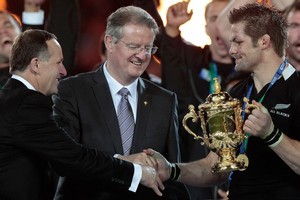 All Blacks captain Richie McCaw (R) receives the Webb Ellis Cup from IRB chairman Bernard Lapasset (C) and New Zealand Prime Minister John Key (L). Photo / Brett Phibbs