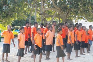 A choir of school children welcomes visitors to Pele. Photo / Isobel Marriner