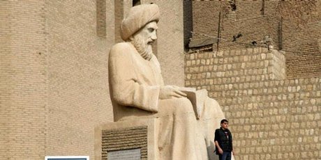 Tourists look at a statue of Kurdish writer Ibn al-Mustawfi at the entrance to the citadel in the northern Iraqi city of Arbil. Photo / AFP