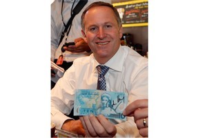 Prime Minister John Key with the note he signed for cafe owner Romeo Jovanoic. Photo / Mark Mitchell