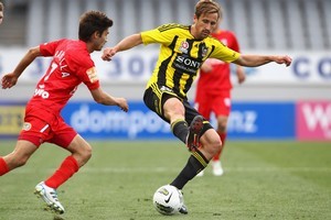 Nicholas Ward of the Wellington Phoenix controls the ball watched by Zenon Caravella of Adelaide United. Photo / Getty Images