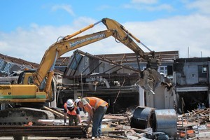 Southern Demolition staff inspect timber at the site of the Lane Walker Rudkin Factory in Christchurch. Tonnes of vintage native timber recovered from Christchurch buildings is heading to Auckland for sale. Photo / Amanda Cropp