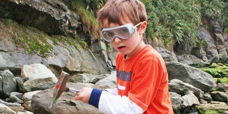 Jamie Tully checks out an interesting rock in his quest for fossils at Kiritehere Beach. Photo / Alex Tully