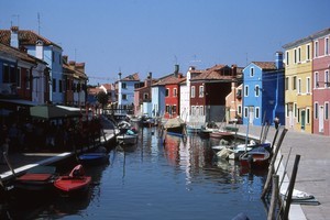 Brightly painted houses reflect in the peaceful canals of Venice's Burano Island. Photo / Paul Rush