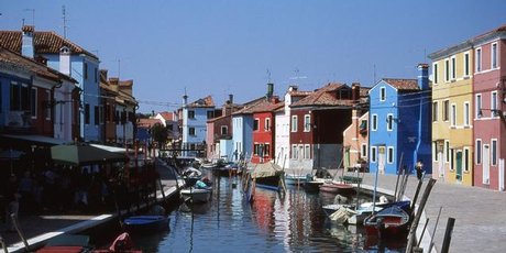 Brightly painted houses reflect in the peaceful canals of Venice's Burano Island. Photo / Paul Rush