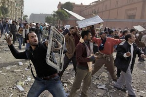 Anti-government protesters throw stones during clashes in Cairo, Egypt. Photo / AP