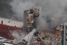 Rescue workers on a burning collapsed building in central Christchurch. Photo / Mark Mitchell