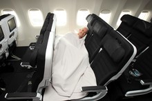 Rob Fyfe,  CEO of Air New Zealand, sleeps on a Skycouch, which is still to be approved by the CAA. Photo / Herald on Sunday