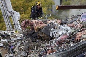 A rescue worker looks for any signs of life in the rubble of the CTV building. Photo / Simon Baker