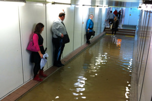 Commuters stand clear of flooding in a Sydney underground railway station. Photo / Supplied