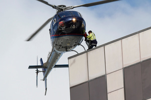 A helicopter picks up a police officer from the roof of the PWC Building in central Christchurch, 24 February 2011. Photo / Mark Mitchell