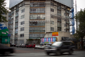 The upper storeys of Hobson Gardens have been enclosed in a protective sheath. Photo / Natalie Slade