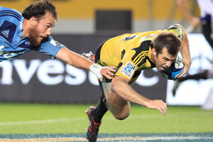 Blues Liaki Moli try's to stop the flying Hurricanes Captain Conrad Smith as he scores the winning try against the Blues during the teams' Super 15 rugby game at Eden Park. Photo / Greg Bowker.