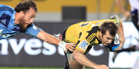 Blues Liaki Moli try's to stop the flying Hurricanes Captain Conrad Smith as he scores the winning try against the Blues during the teams' Super 15 rugby game at Eden Park. Photo / Greg Bowker.