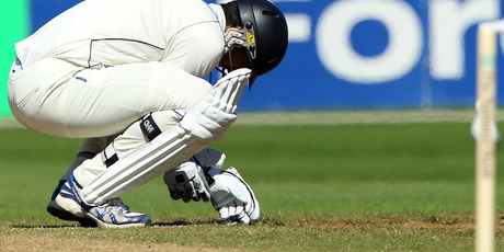 Ross Taylor reacts after sustaining an arm injury. Photo / Getty Images